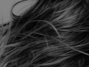 Close-up black and white photo of long, wavy, textured hair